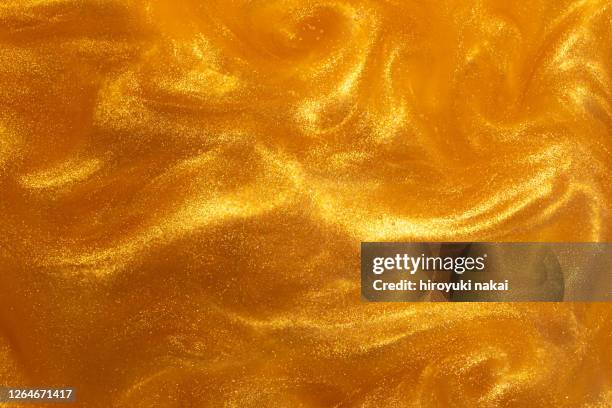 gold paint dissolved in water - limoso fotografías e imágenes de stock