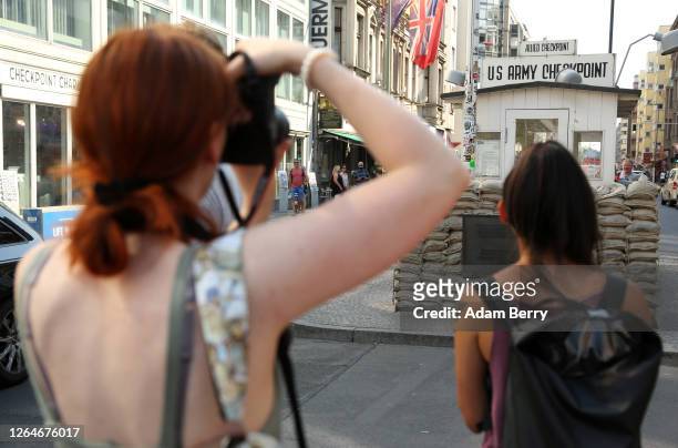 Tourists take pictures of the former Checkpoint Charlie on August 08, 2020 in Berlin, Germany. Industry experts say that tourism in Germany may need...