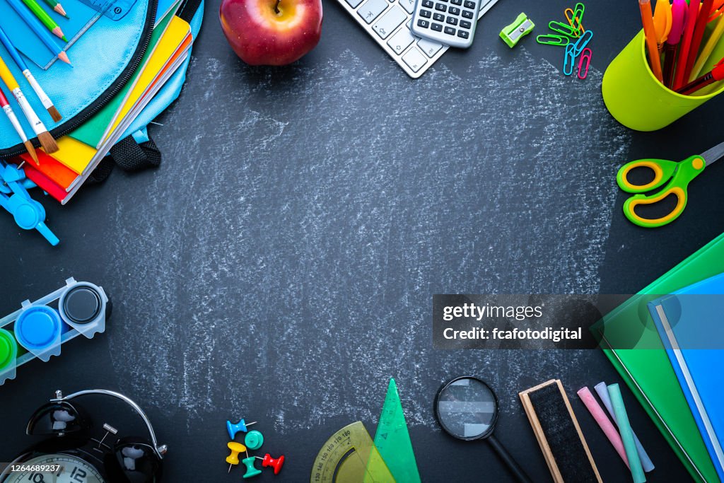 School or office supplies border on blackboard background. Copy space
