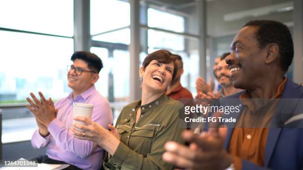 business people applauding their colleague after seminar in board room - applauding stock pictures, royalty-free photos & images