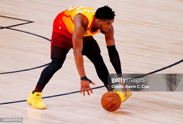 Donovan Mitchell of the Utah Jazz lets the ball roll up the court without touching it to avoid the clock stopping against the Denver Nuggets during...