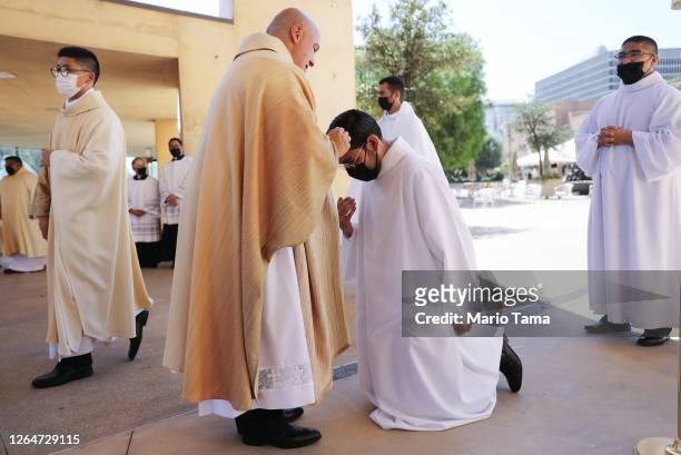 Newly ordained priest gives a first blessing to an altar server following the first-ever outdoor Ordination Mass at the Cathedral of Our Lady of the...