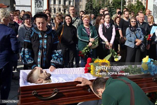 Relatives and friends cry near the coffin with the body of military serviceman Yuriy Samaniuk during the funeral at Independence Square. In the...