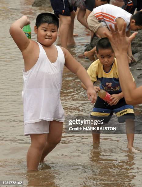 An young overweight boy known locally as a 'Little Emporer' plays by the Yangtze river in Chongqing, 21 August 2006. China is sounding the alarm bell...