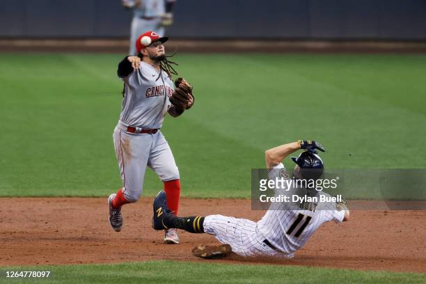 Freddy Galvis of the Cincinnati Reds turns a double play past Brock Holt of the Milwaukee Brewers in the third inning at Miller Park on August 08,...