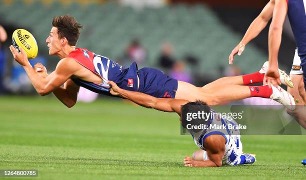 Sam Weideman of the Demons handballs over Aaron Hall of the Kangaroos during the round 11 AFL match between the Melbourne Demons and the North...