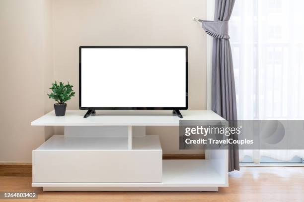 smart tv on the cabinet in modern living room on white wall background. modern white shelf with flat tv at home - living room television stock-fotos und bilder
