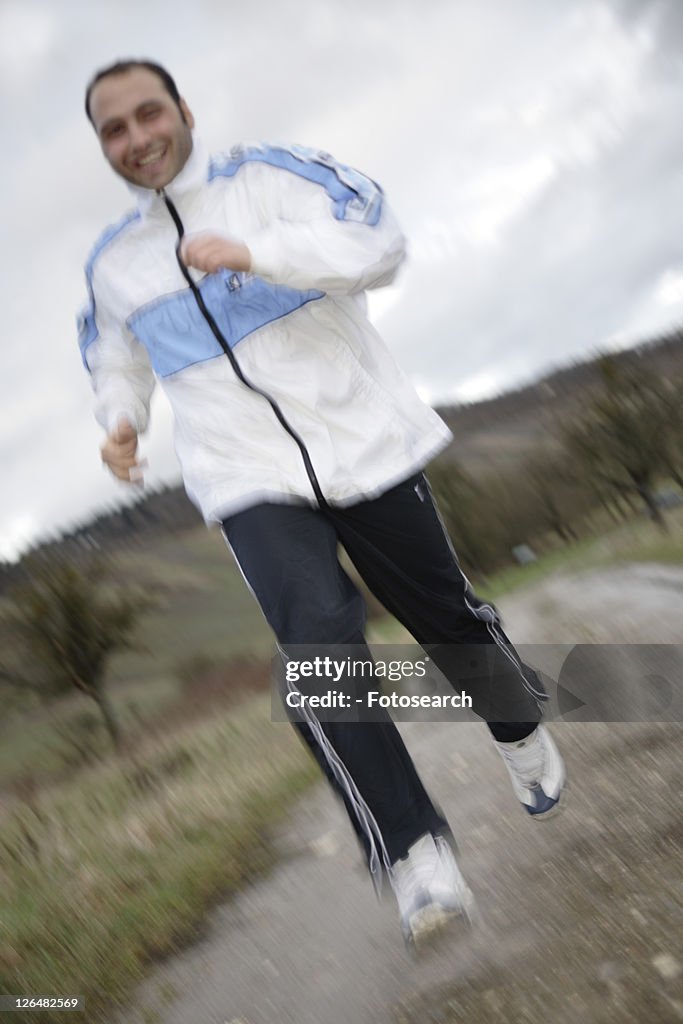 Young man jogging in spite of bad weather