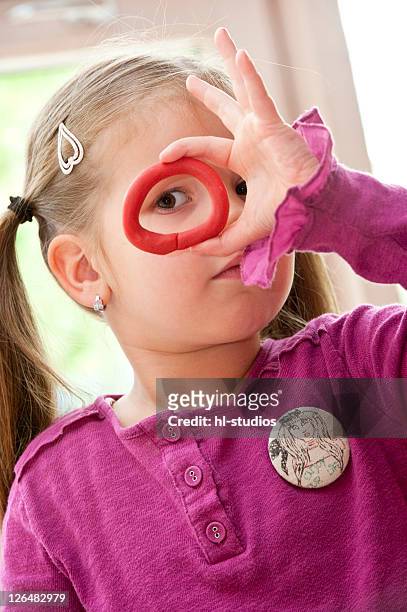 young girl looking through a piece of plasticine, portrait - clay earring stock pictures, royalty-free photos & images