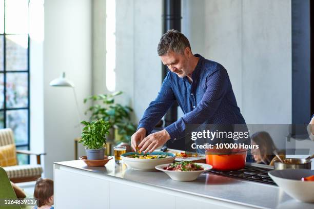 mature man preparing healthy meal on kitchen counter - 住宅廚房 個照片及圖片檔