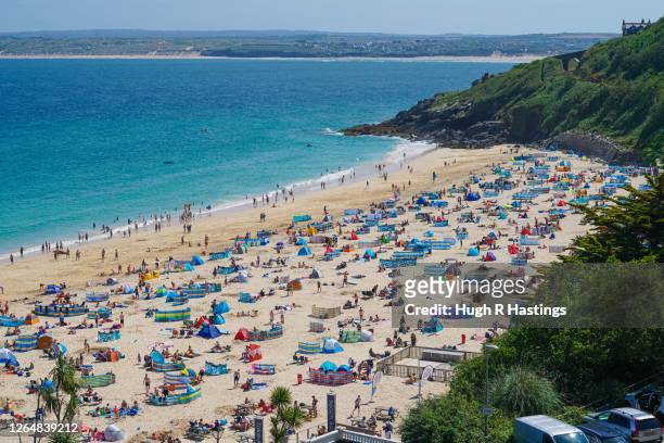 Holiday makers on Porthminster Beach on August 9, 2020 in St Ives, Cornwall, England. The RNLI has called on beachgoers in the south west of England...