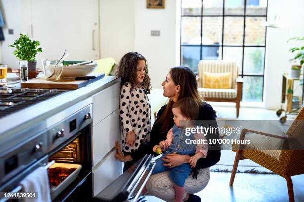 mother cooking at home with two children - hot latino girl imagens e fotografias de stock