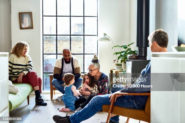 multi ethnic family relaxing on weekend in living modern room - multi generation family stock pictures, royalty-free photos & images