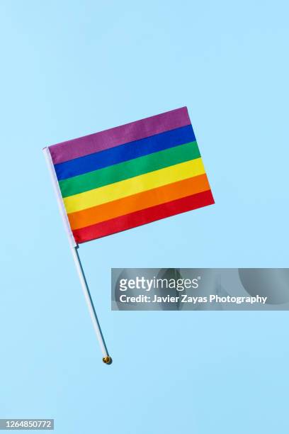 rainbow flag on blue background - gay flag stock pictures, royalty-free photos & images