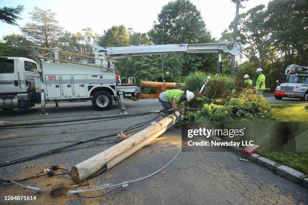 In an effort to restore electricity and other services on Aug. 5 workers from Verizon remove downed wires from one of several utility poles that were...