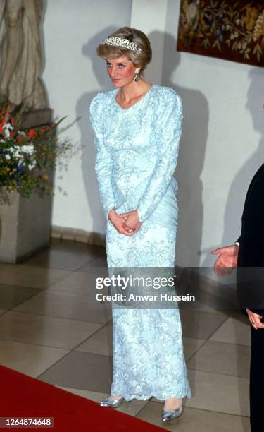 Diana, Princess of Wales, wearing a blue chiffon and lace dress with sequins designed by Catherine Walker, the leaf and flower diamond Spencer family...