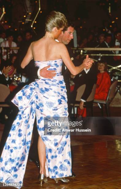 Prince Charles, Prince of Wales and Diana, Princess of Wales, wearing a blue chintz taffeta ballgown by Catherine Walker, dance together at a dinner...