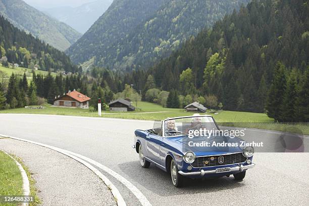 senior couple driving convertible on country road, italy - old car bildbanksfoton och bilder