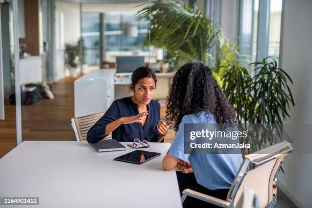 indische onderneemster die haar situatie aan haar medewerker verklaart - complaints stockfoto's en -beelden