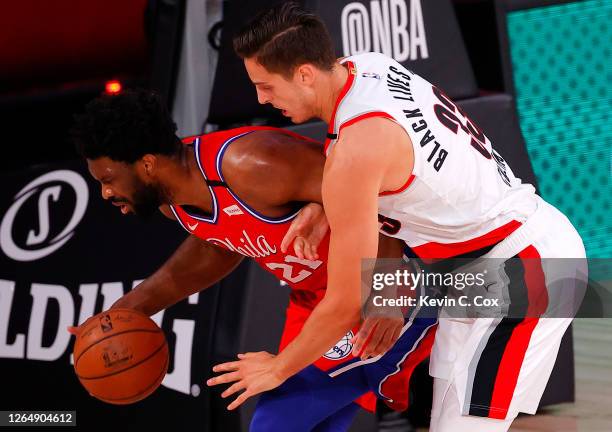 Joel Embiid of the Philadelphia 76ers is fouled by Zach Collins of the Portland Trail Blazers at Visa Athletic Center at ESPN Wide World Of Sports...