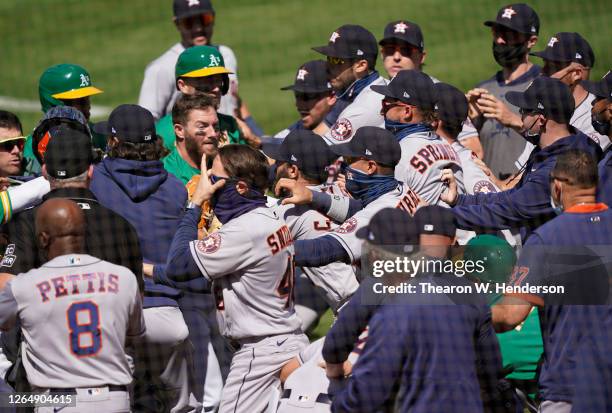 Players from the Houston Astros and Oakland Athletics get into a shoving match after Ramon Laureano of the Athletics was hit by a pitch and charged...
