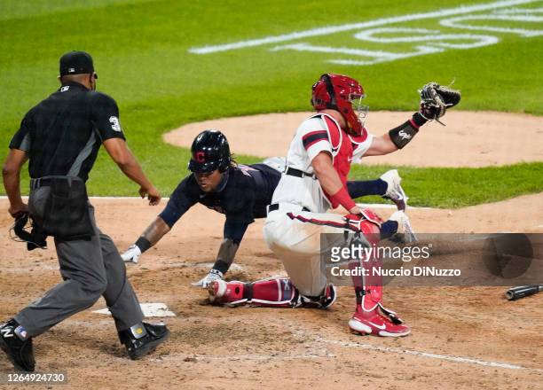 Jose Ramirez of the Cleveland Indians scores past James McCann of the Chicago White Sox during the 10th inning against the Chicago White Sox on...