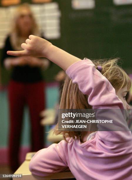 Une écolière de cours préparatoire lève la main en classe, le 12 décembre 2005 dans une école de Vacherauville.