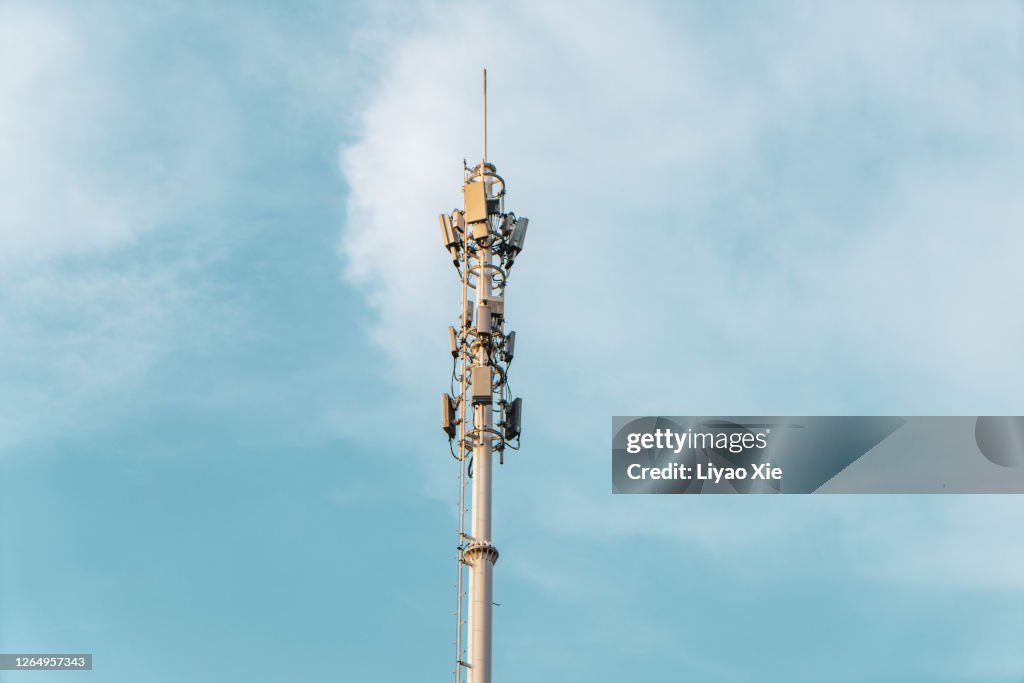 Telecommunications Tower with antennas on blue sky with cloud