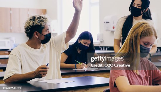 Gymnasielärare och elever i klassrummet bär skyddande ansiktsmask Gymnasielärare och elever i klassrummet bär skyddande ansiktsmask