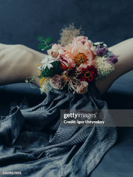 young naked woman lying on floor with bouquet - scheide stock-fotos und bilder