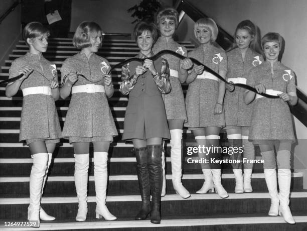Marlène Jobert coupe le ruban symbolique de pellicule, entourée d'hôtesses en tailleur-bermuda, au cinéma 'Le Concorde' à Paris, France le 16...
