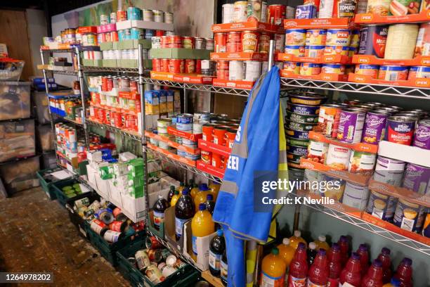 estantes de banco de alimentos llenos de alimentos enlatados donados listos para su distribución - food pantry fotografías e imágenes de stock