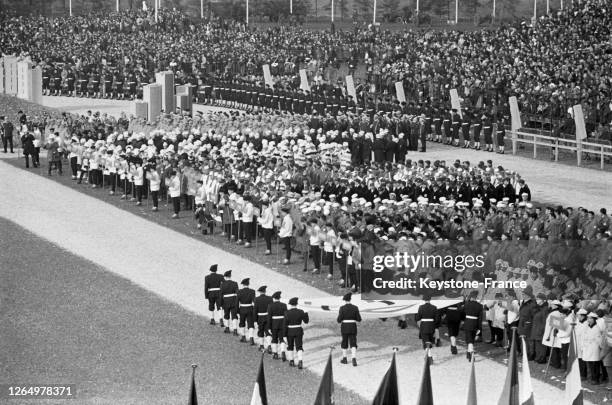 Arrivée du drapeau olympique porté par les chasseurs alpins lors de la cérémonie d'ouverture des Jeux olympiques à Grenoble, France en février 1968.