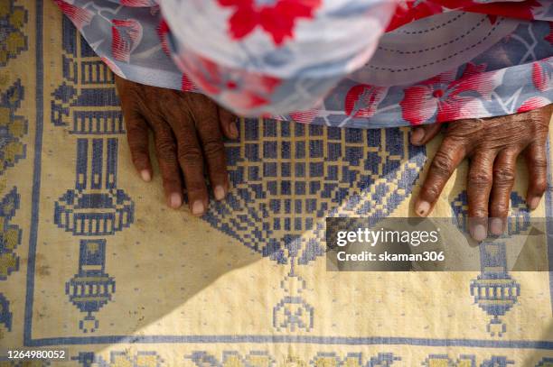 muslim female praying to allah with mosque ground sheet - saudi arabia city stock pictures, royalty-free photos & images