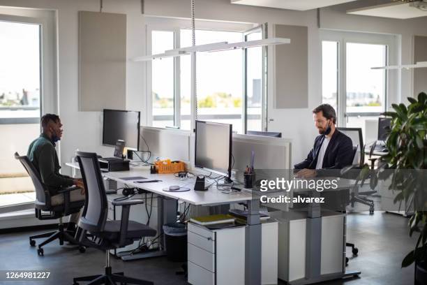 business men working in office during pandemic - health and safety covid stock pictures, royalty-free photos & images