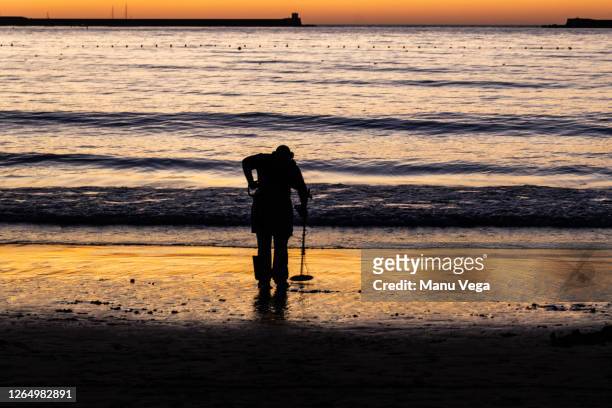 treasure hunter with metal detector on the sunset the beach. - treasuregold bildbanksfoton och bilder