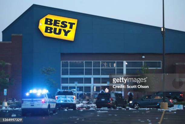 Police officers inspect a damaged Best Buy store after parts of the city had widespread looting and vandalism, on August 10, 2020 in Chicago,...