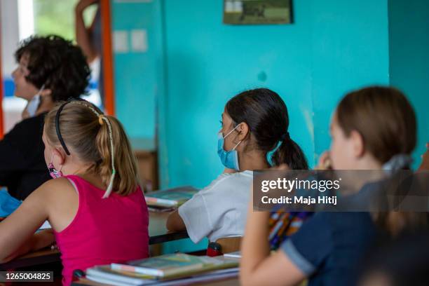 Children wearing protective face masks sit in classroom for the first day of classes of the new school year at the GuthsMuths elementary school...