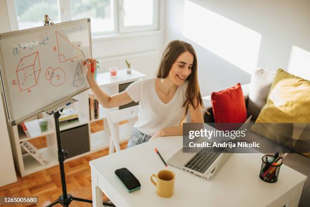 young female teacher is having online class and showing pythagorean theorem - online instructor stock pictures, royalty-free photos & images