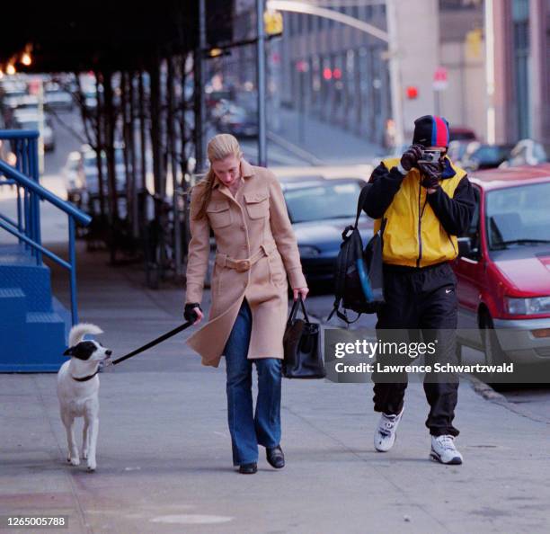 John F. Kennedy Junior and wife Carolyn Bessette and dog take a stroll in Tribeca. John takes photos with a Leica camera of the photographers.
