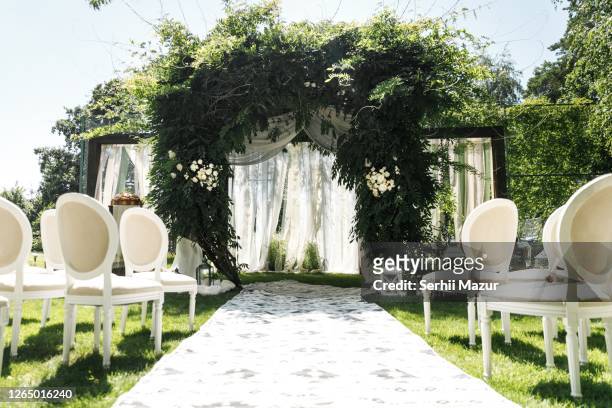 wedding arch decorated with greenery outdoors - stock photo - wedding stock pictures, royalty-free photos & images