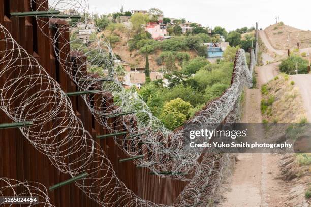 the us/mexico border fence in nogales, arizona usa - razor wire stock pictures, royalty-free photos & images