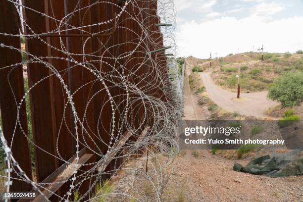 the us/mexico border fence in nogales, arizona usa - nogales stock pictures, royalty-free photos & images