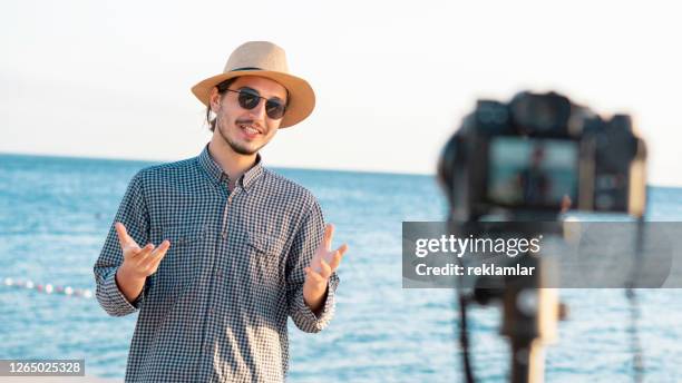 young man making video chat with his followers on social media at the sea shore. technology social media internet youth concepts. - actress icon stock pictures, royalty-free photos & images