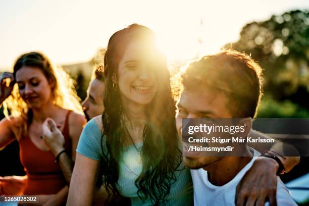 lachendes junges paar hängt mit freunden an einem sonnigen sommernachmittag - freund stock-fotos und bilder