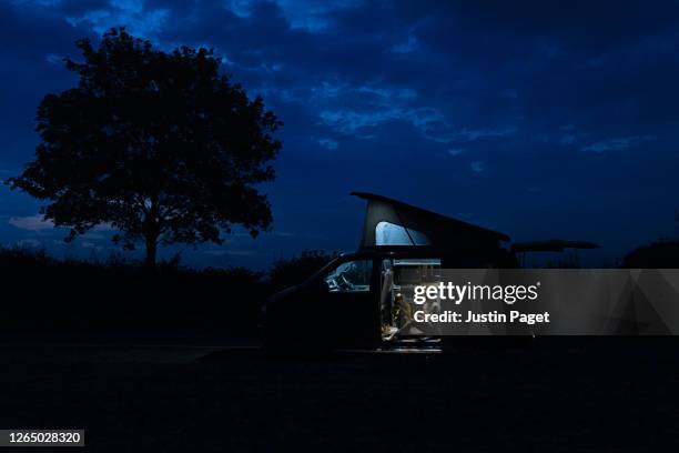 woman talks to her daughter in their campervan at night - road trip kids stock pictures, royalty-free photos & images