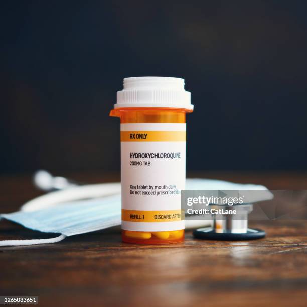 stethoscope and face mask with prescription medication in pill bottle: hydroxychloroquine phosphate - systemic lupus erythematosus stock pictures, royalty-free photos & images