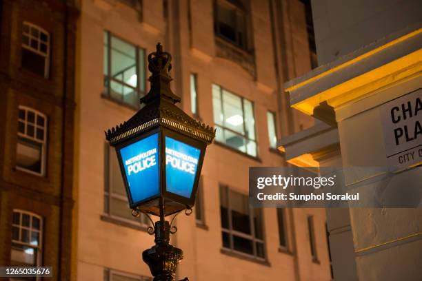 blue metropolitan police lantern in front of a police station in london at night - london police stock pictures, royalty-free photos & images