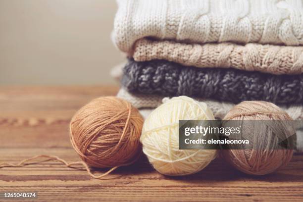 stapel truien op een houten lijst - wollig stockfoto's en -beelden