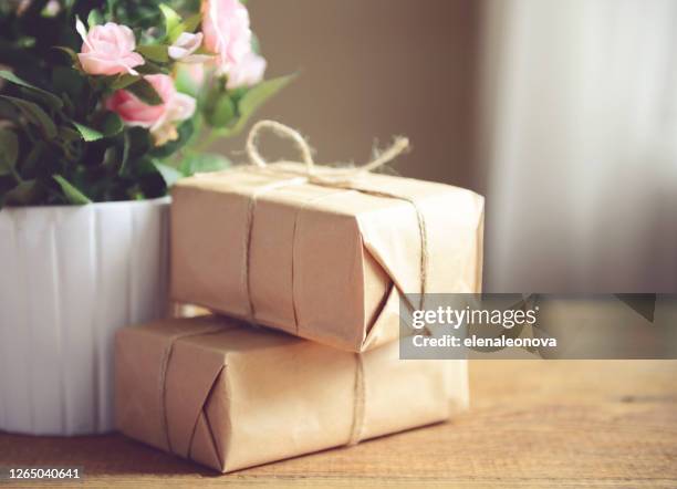 schachteln aus kraftpapier auf einem holztisch - white flower paper stock-fotos und bilder